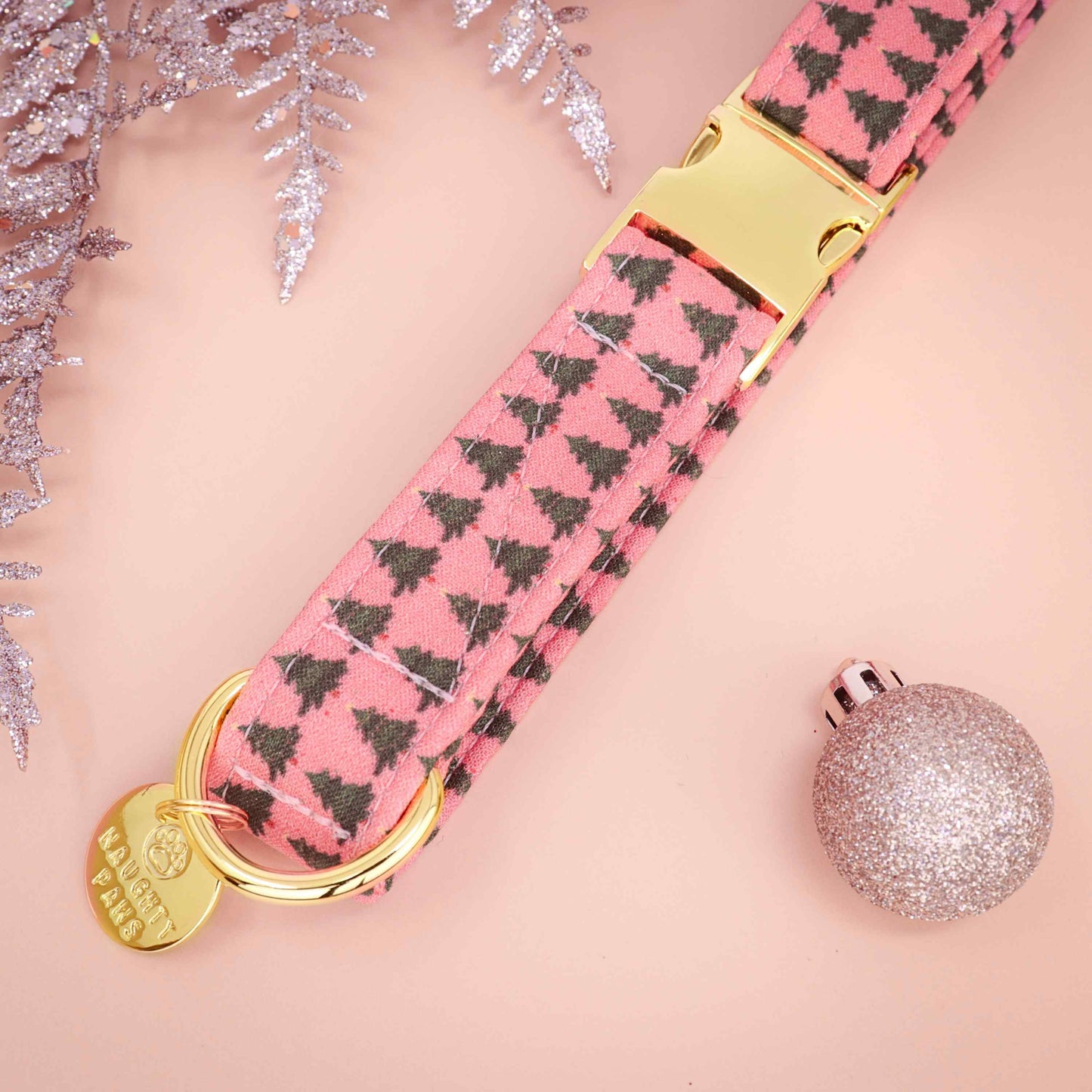 red dog collar with black tree pattern and gold hardware on a pink background