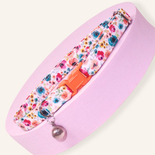 Handmade wildflower breakaway cat collar featuring colorful floral prints, coral safety buckle, silver bell, and adjustable cotton design for kittens and adult cats.