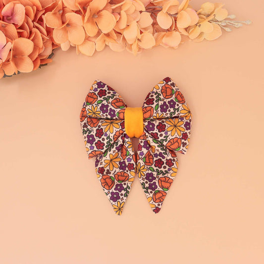 Golden Poppy dog sailor bow with orange, yellow, and purple floral print, handmade slide-on collar bow for autumn pets
