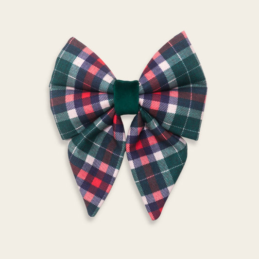 Handmade Christmas plaid dog sailor bow featuring green, red, navy, and pink tartan fabric with a velvet center, designed to slide over a dog collar for a festive holiday look.
