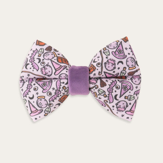 purple Halloween dog bow tie featuring witches, potion bottles, moons, stars and witch hats