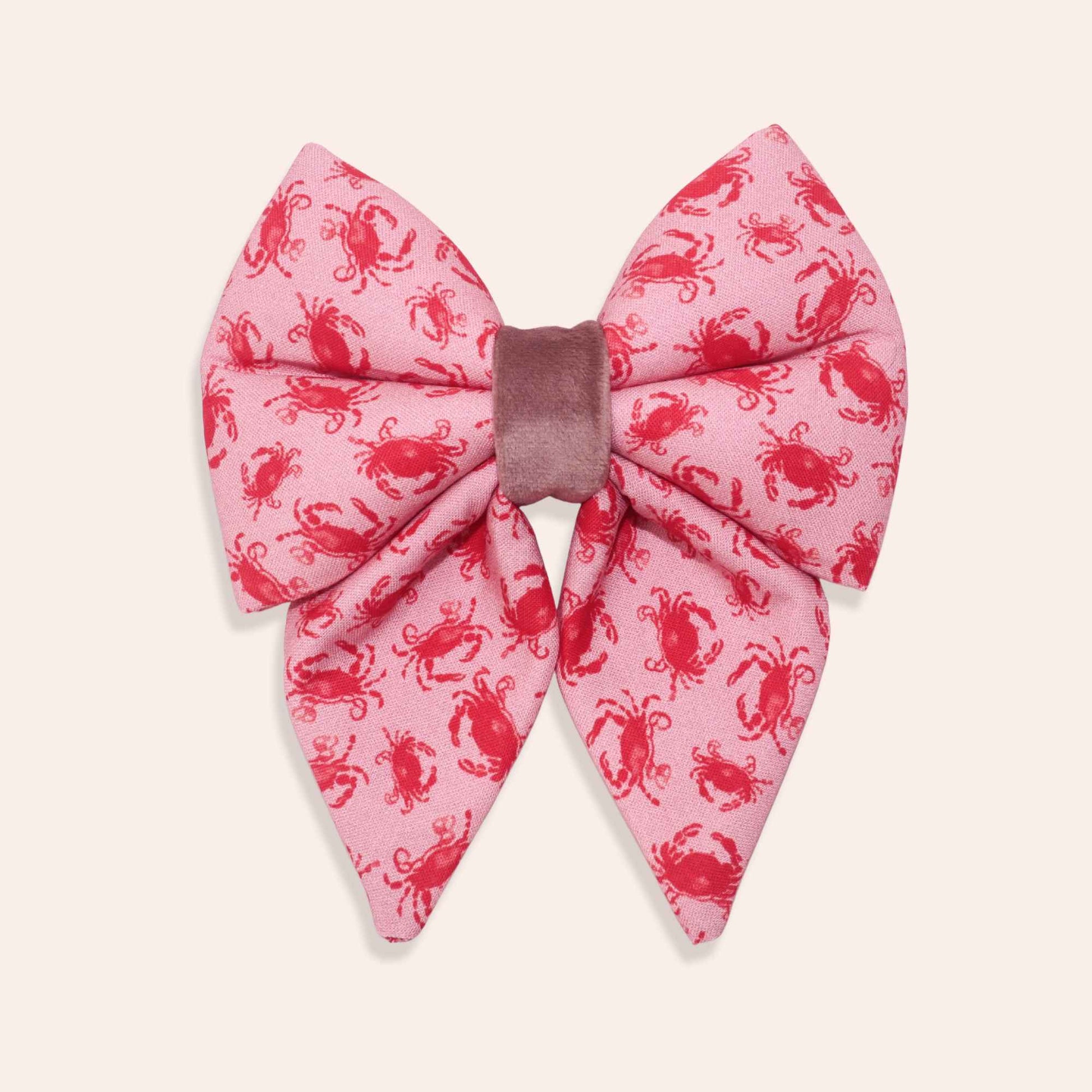 Pink coral dog bow with red crab pattern on a white background