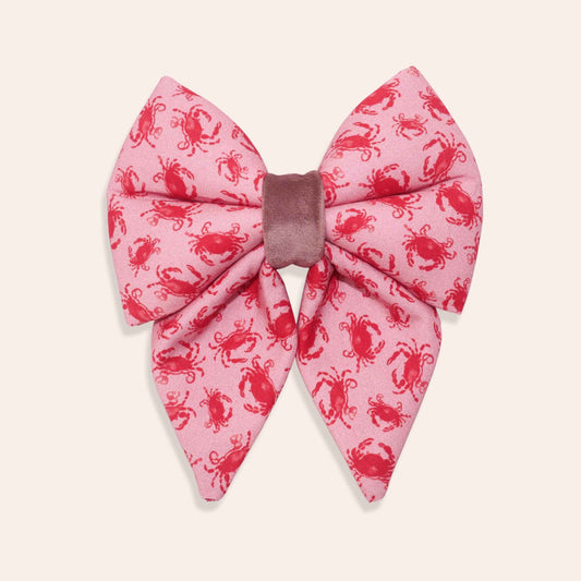 Pink coral dog bow with red crab pattern on a white background