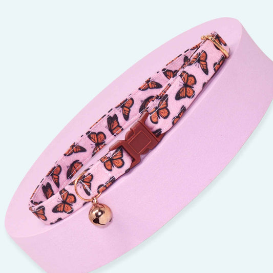 Pink breakaway cat collar featuring orange monarch butterflies, rose gold hardware, and an optional bell.
