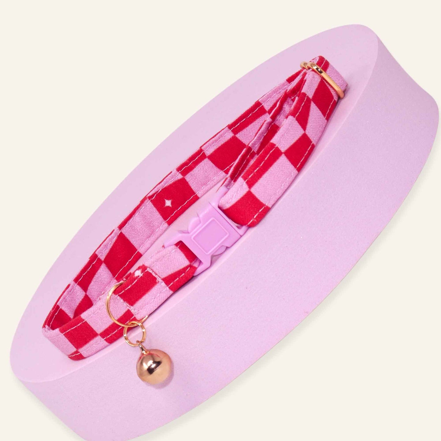 Pink groovy checkered cat collar with rose gold hardware and a pink breakaway buckle.