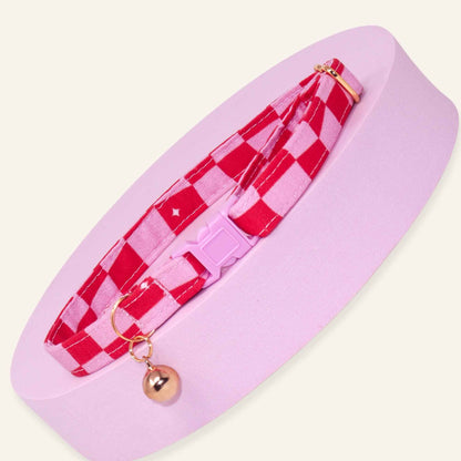 Pink groovy checkered cat collar with rose gold hardware and a pink breakaway buckle.