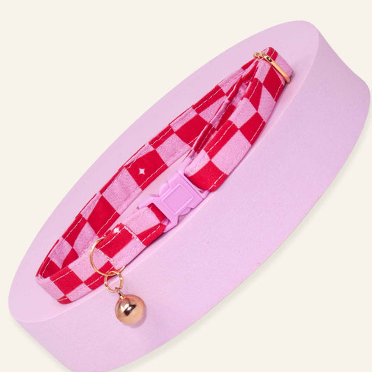 Pink groovy checkered cat collar with rose gold hardware and a pink breakaway buckle.