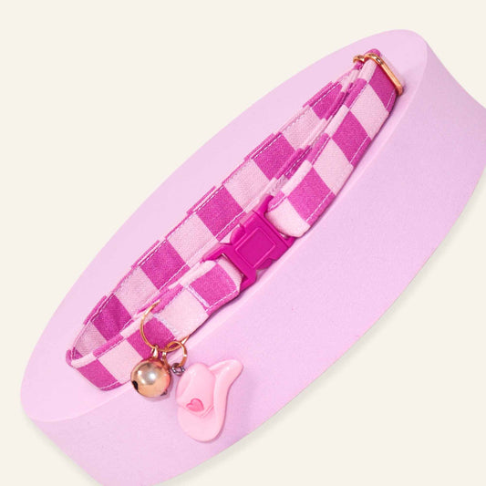 Pink gingham breakaway cat collar featuring a hot pink and blush checkered pattern, rose gold bell, and cowgirl hat charm.