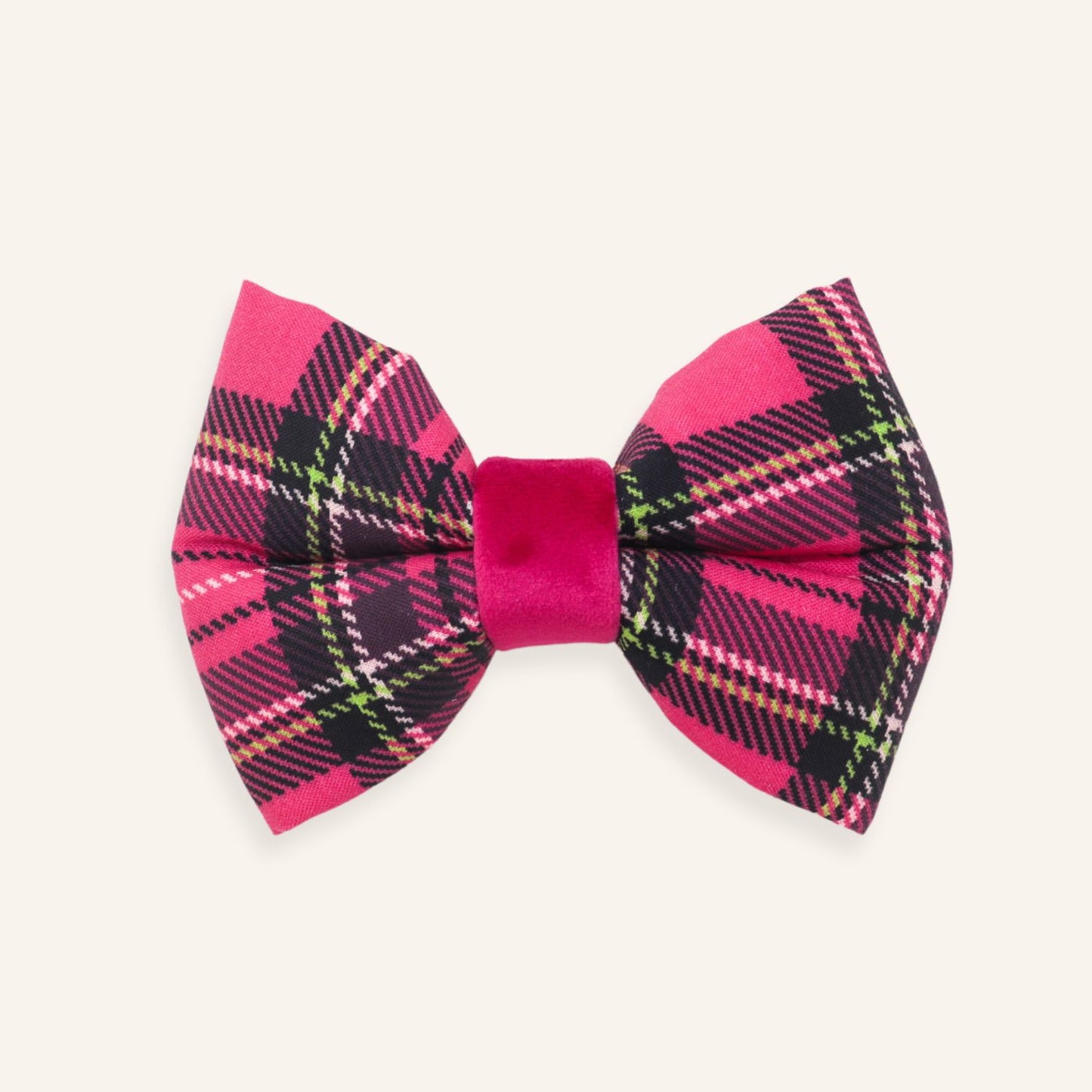 A pink and black plaid bow tie with a solid magenta velvet center band, displayed on a light cream background.