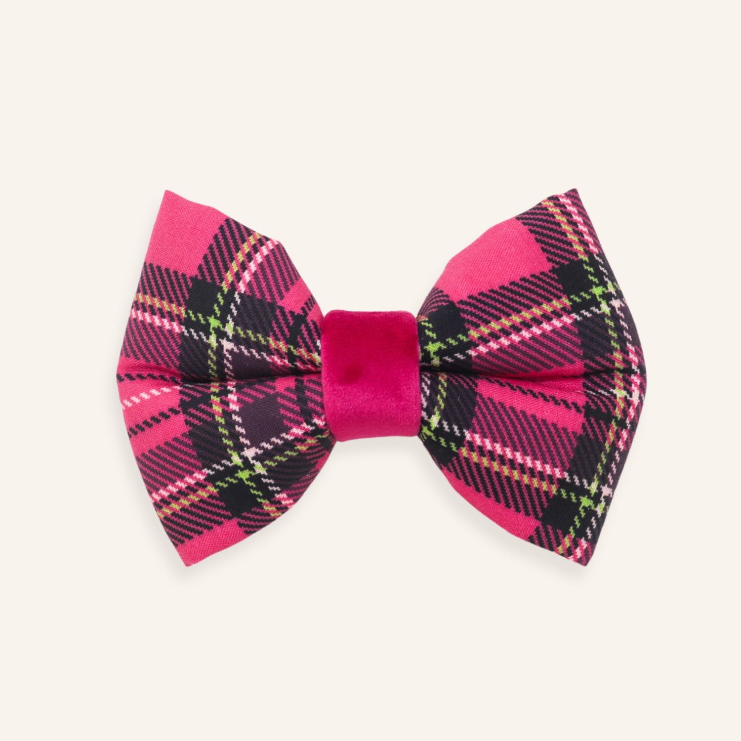 A pink and black plaid bow tie with a solid magenta velvet center band, displayed on a light cream background.