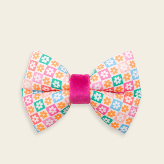 Handmade Retro Floral dog bow tie featuring colorful pastel daisy checkered fabric with a hot pink center, designed as an over-the-collar accessory for dogs.